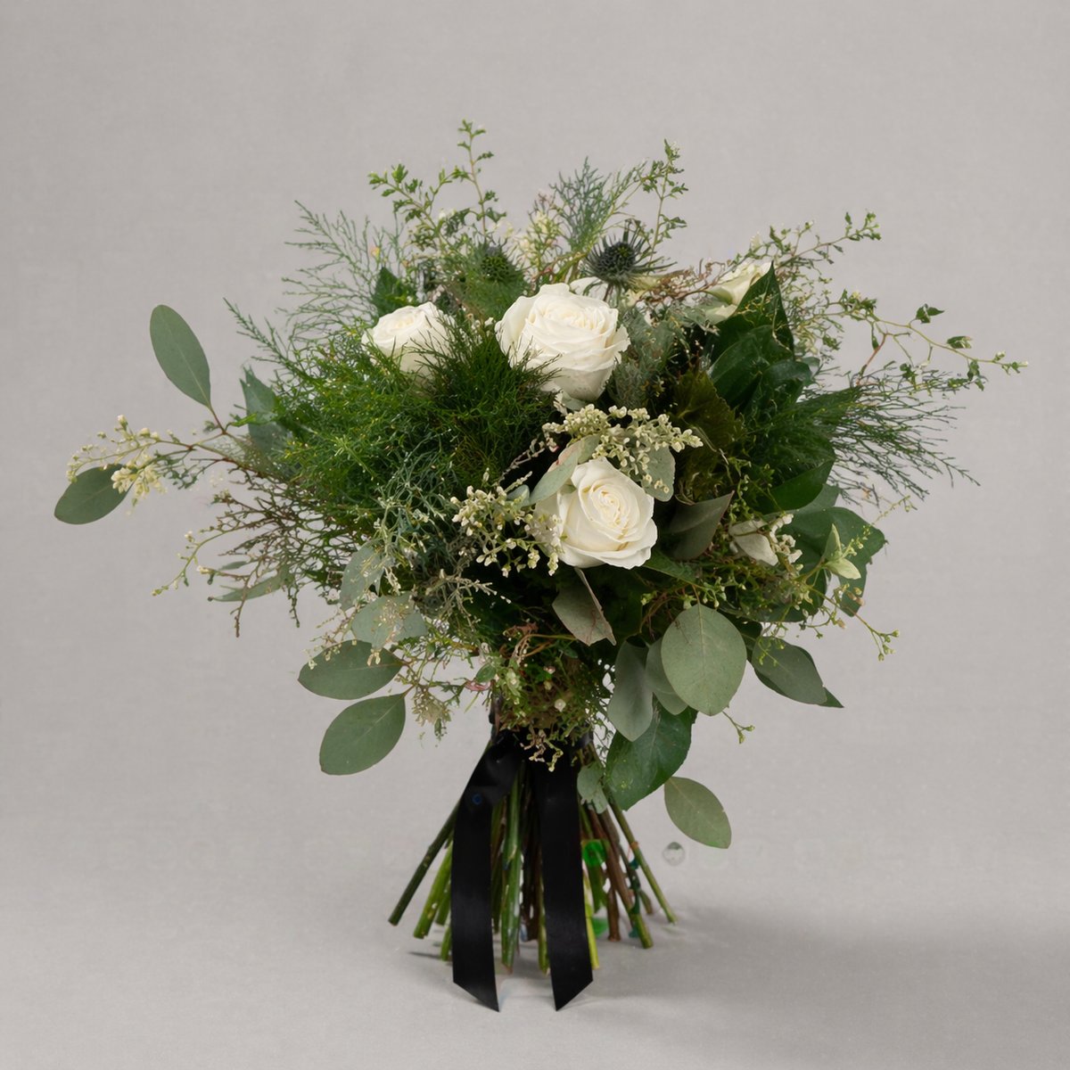 Hand-tied white rose prom bouquet with greenery, eucalyptus, and ribbon wrap, styled for formal events and prom flowers.
